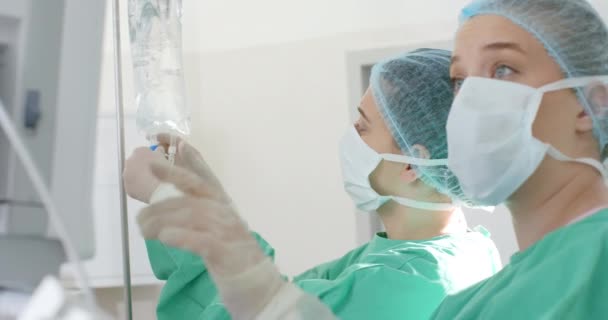 Cirurgiões Diversos Vestindo Batas Cirúrgicas Aplicando Gotejamento Sala Operações Câmera — Vídeo de Stock