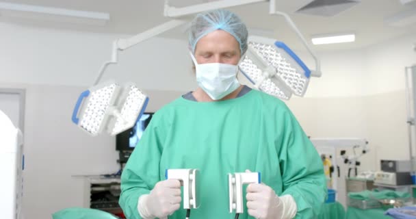 Retrato Cirurgião Caucasiano Vestindo Vestido Cirúrgico Segurando Desfibrilador Câmera Lenta — Vídeo de Stock