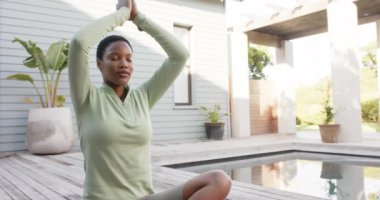 Yoga ve bahçede meditasyon yapan çift ırklı bir kadın. Ağır çekimde. Yaz, refah, zindelik ve sağlıklı yaşam tarzı, değişmedi..
