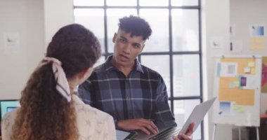 Gündelik ofiste dizüstü bilgisayarda tartışan iki farklı yaratıcı tasarımcı, yavaş çekim. Günlük ofis takım çalışması, iş, tasarım ve yaratıcı çalışma, değiştirilmemiş.