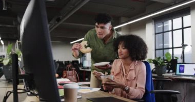 İki farklı yaratıcı iş arkadaşı öğle yemeğinde rahat ofiste tartışıyor, ağır çekimde. Günlük ofis takım çalışması, iş, tasarım ve yaratıcı çalışma, değiştirilmemiş.