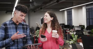 İki farklı yaratıcı tasarımcı günlük ofiste, tablette tartışıyorlar, ağır çekimde. Günlük ofis takım çalışması, iş, tasarım ve yaratıcı çalışma, değiştirilmemiş.