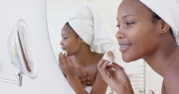 Mulher Biracial Feliz Com Toalha Cabeça Olhando Espelho Lavar Rosto — Vídeo de Stock