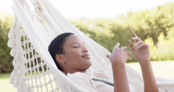 Mujer Afroamericana Feliz Tumbada Hamaca Terraza Usando Smartphone Cámara Lenta — Vídeos de Stock