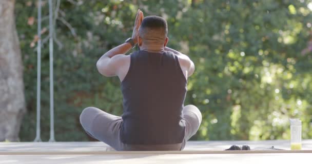 Fokuserad Afrikansk Amerikansk Man Gör Yoga Meditation Däck Solig Trädgård — Stockvideo