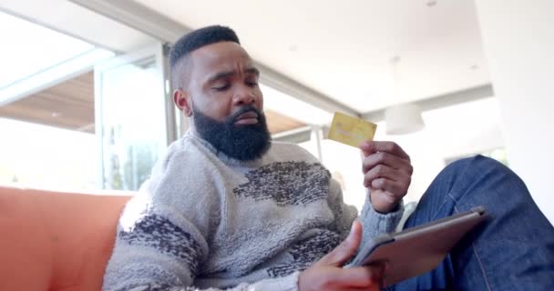 Afro Amerikaanse Man Met Behulp Van Tablet Creditcard Zonnige Woonkamer — Stockvideo