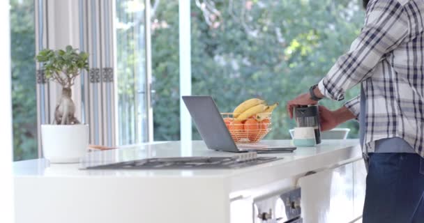 Afrikai Amerikai Férfi Kávét Főz Laptopot Használ Napsütötte Konyhában Lassított — Stock videók