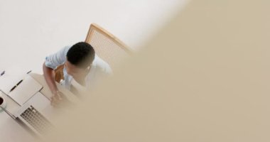 Masada kulaklık takan Afrikalı Amerikalı bir kadın, video görüşmesi için laptop kullanıyor, yavaş çekim. Yaşam tarzı, iletişim, video çağrısı ve ev hayatı, evden çalışma, uzaktan çalışma, değiştirilmemiş.