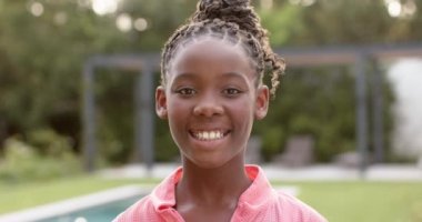 Afrikalı Amerikalı mutlu bir kızın portresi bahçede gülümsüyor, ağır çekimde. Mutluluk, rahatlama ve refah, değişmemiş..