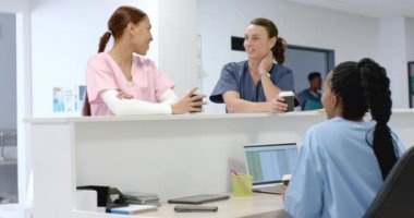 Muhtelif doktorlar hastanede resepsiyonistle konuşuyor, ağır çekimde. Hastane, takım çalışması, iletişim, tıp, sağlık ve iş, değiştirilmemiş.