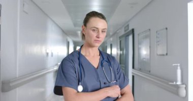 Koridorda önlük ve steteskop giyen beyaz kadın doktor portresi, ağır çekimde. Hastane, ilaç, sağlık ve iş, değiştirilmemiş.