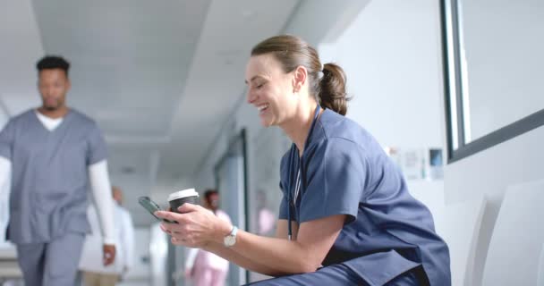 白人女医生使用智能手机和喝咖啡在走廊 复制空间 慢动作 保健和工作 — 图库视频影像