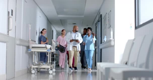 Zróżnicowani Lekarze Korzystający Tabletu Chodzący Korytarzem Szpitalu Zwolnione Tempo Szpital — Wideo stockowe