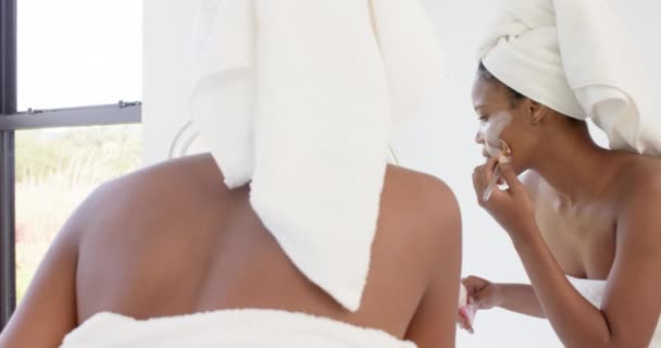 バスルームで顔にマスクを作る頭の上にタオルで焦点を当てた出産の女性 スローモーション 国内生活 健康とセルフケア 変更なし — ストック動画