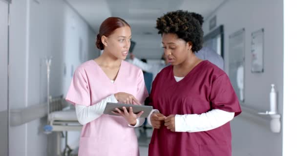 Różnorodne Kobiety Lekarzy Omawiających Pracę Korzystania Tabletu Korytarzu Zwolnione Tempo — Wideo stockowe