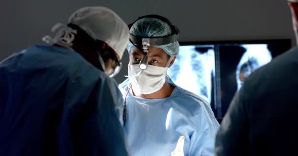 手術用ガウンを身に着けている多様な外科医は 動作する劇場で患者に動作し ゆっくり動きます チームワーク 医療および仕事 変わらない — ストック動画