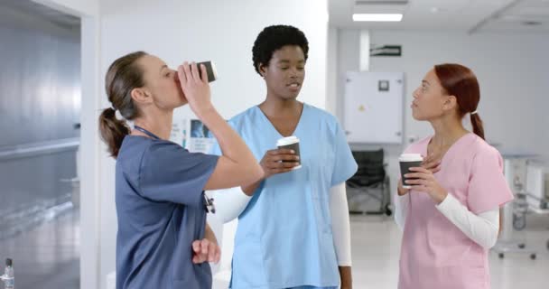 不同的女医生在医院聊天喝咖啡 动作缓慢 团队合作 保健和工作 — 图库视频影像