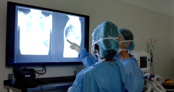 Cirurgiões Diversos Vestindo Batas Cirúrgicas Olhando Para Radiografias Sala Operações — Vídeo de Stock