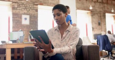 Tablet kullanan ve ofiste ağır çekimde yürüyen mutlu Afro-Amerikan meslektaşlarının portresi. İş, teknoloji ve takım çalışması, değiştirilmemiş.