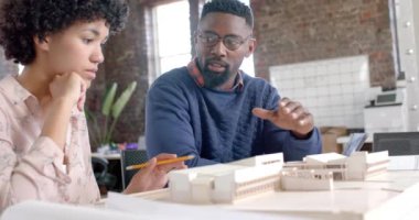 Çeşitli mimari meslektaşlar ofis modelleriyle ağır çekimde çalışmayı tartışıyorlar. İş, beyin fırtınası, mimari, tasarım ve takım çalışması, değiştirilmemiş.