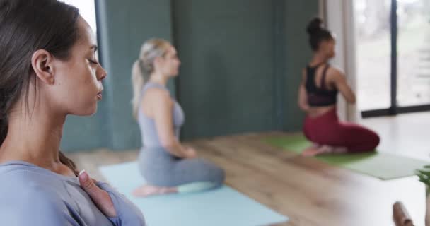 胸の手とクラスで呼吸練習を実践胃を持つ多様な女性 変更されていない スローモーション フィットネス 瞑想と幸福の概念 — ストック動画