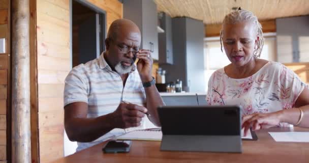 Oudere Afrikaans Amerikaanse Echtpaar Doet Papierwerk Met Behulp Van Tablet — Stockvideo