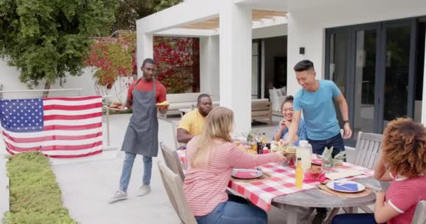 Afroamerikansk Man Serverar Mat Till Olika Vänner Vid Middagsbordet Trädgården — Stockvideo