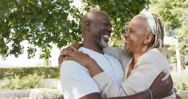 日当たりの良い庭 スローモーションに包まれた幸せなアフリカ系アメリカ人のシニアカップルの肖像画 国内生活や高齢者のライフスタイル 変更なし — ストック動画