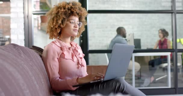 Pensativo Birracial Mujer Negocios Casual Utilizando Ordenador Portátil Sofá Oficina — Vídeo de stock