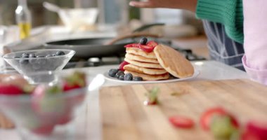 Afrika kökenli Amerikalı anne ve kızının mutfakta kreplere bal dökmesi, ağır çekimde. Yaşam tarzı, aile, birliktelik, yemek, aşçılık ve ev hayatı, değişmemiş..