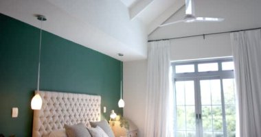 Güneşli yatak odasını yeşil duvarlı, yavaş çekimde kapatın. Yaşam tarzı, iç tasarım ve ev hayatı..