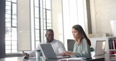 Ofiste tartışan dizüstü bilgisayar ve tablet kullanan mutlu meslektaşlar, kopyalama alanı, yavaş çekim. İş, iş, takım çalışması, iletişim ve günlük ofis, değiştirilmemiş.