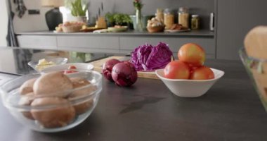 Mutfaktaki tezgahın üstündeki kaselerdeki yiyecekleri yavaş çekimde kapat. İç mekan, yemek, yemek, hazırlık ve ev hayatı.