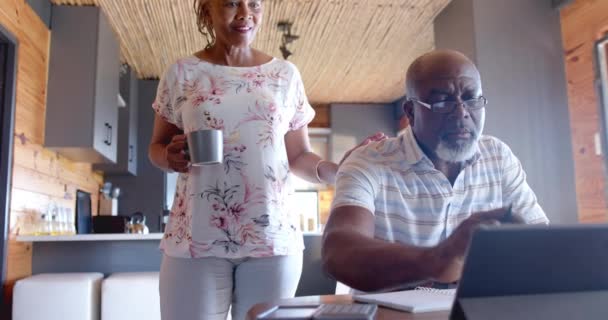 Couple Afro Américain Senior Faisant Paperasse Utilisant Une Tablette Maison — Video