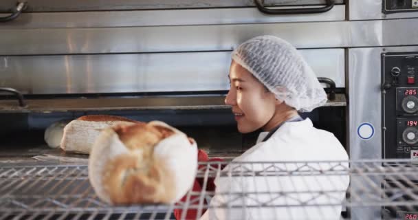 Счастливая Азиатская Пекарь Работает Пекарне Выкладывая Свежий Хлеб Замедленной Съемке — стоковое видео