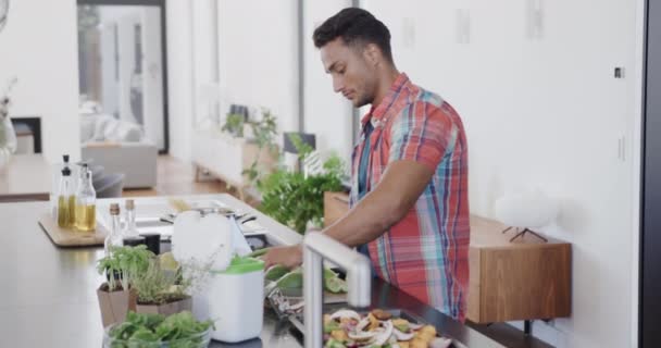 Hombre Biracial Preparando Comida Compostaje Residuos Vegetales Cocina Moderna Cámara — Vídeo de stock