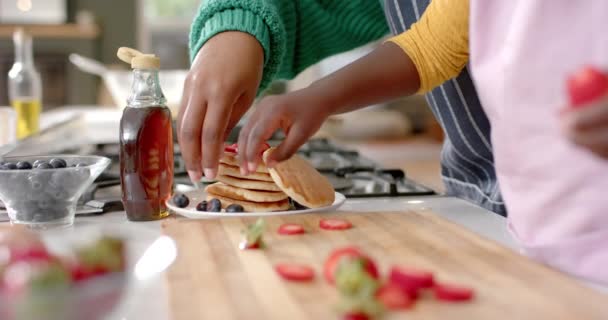 美国黑人母亲和女儿用水果装饰煎饼 动作缓慢 生活方式 烹调和家庭生活 — 图库视频影像