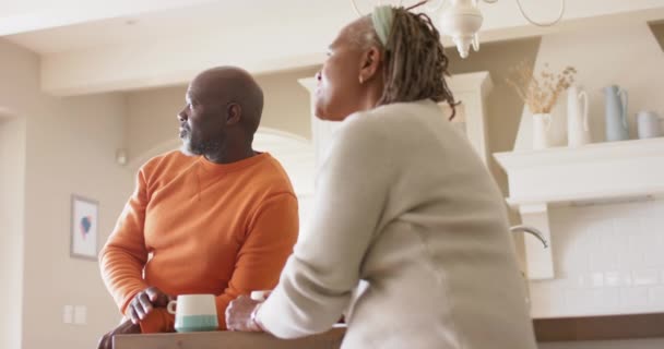Onnellinen Afrikkalainen Amerikkalainen Vanhempi Pari Puhuu Juo Kahvia Keittiössä Hidastettuna — kuvapankkivideo