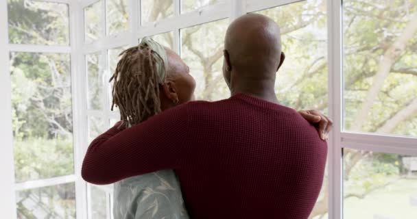 Ευτυχισμένο Ζευγάρι Αφροαμερικανών Που Αγκαλιάζει Και Κοιτάζει Έξω Από Παράθυρο — Αρχείο Βίντεο