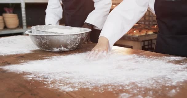 パン屋のキッチンで働く多様なパン屋は スローモーションでカウンターに小麦粉を広げています チームワーク 食べ物 小規模ビジネス ベーキング パン屋 変更なし — ストック動画