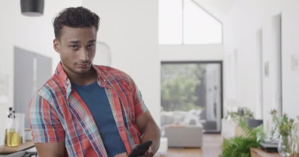 Retrato Homem Biracial Feliz Apartamento Moderno Ensolarado Usando Smartphone Espaço — Vídeo de Stock