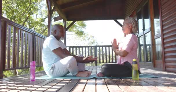 Pareja Afroamericana Mayor Enfocada Cogida Mano Practicando Yoga Terraza Soleada — Vídeo de stock