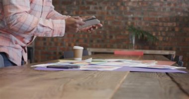 Afro-Amerikan erkek yaratıcılığının orta kesimi tablet kullanıyor ve tasarımlara bakıyor, ağır çekimde. Günlük iş, iletişim, beyin fırtınası, tasarım ve çalışma.