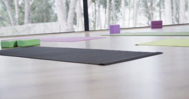 Renkli yoga minderleri, mantar tıkaçları ve yoga stüdyosunda yerde şarkı söyleyen kaseler. Değiştirilmemiş, yavaş çekim, yoga, egzersiz, fitness, zen ve refah kavramı.