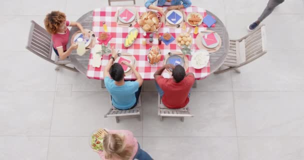 庭のディナーテーブルで友人に食べ物を提供する多様な男女 ゆっくりとした動き 食べ物 お祝い トータルネス ライフスタイル 家庭生活 変わらない — ストック動画