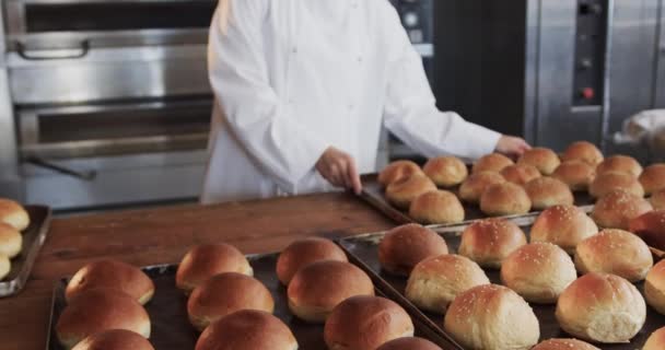 一个快乐的亚洲女面包师在面包店厨房里慢动作地在柜台上放着新鲜的面包卷的画像 小企业 烘焙和工作 未加改动 — 图库视频影像