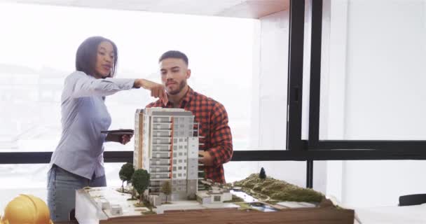 不同的男性和女性建筑师在办公室讨论建筑模型 动作缓慢 团队合作 临时办公室和工作 未经改动 — 图库视频影像