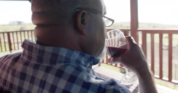 Ανώτερος Αφροαμερικάνος Πίνει Κρασί Στην Ηλιόλουστη Βεράντα Αργή Κίνηση Ανώτερος — Αρχείο Βίντεο