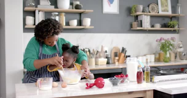 Onnellinen Afrikkalainen Amerikkalainen Äiti Tytär Valmistelee Taikinaa Kulhossa Keittiössä Hidastettuna — kuvapankkivideo