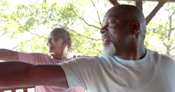 Χαρούμενο Ζευγάρι Αφροαμερικανών Που Κάνουν Γιόγκα Στην Ηλιόλουστη Βεράντα Αργή — Αρχείο Βίντεο